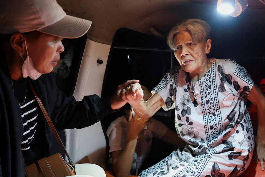 Local people rescue an elderly woman during a fire at Werdha Damai retirement home in Manado, North Sulawesi Province, Indonesia, December 28, 2025.
