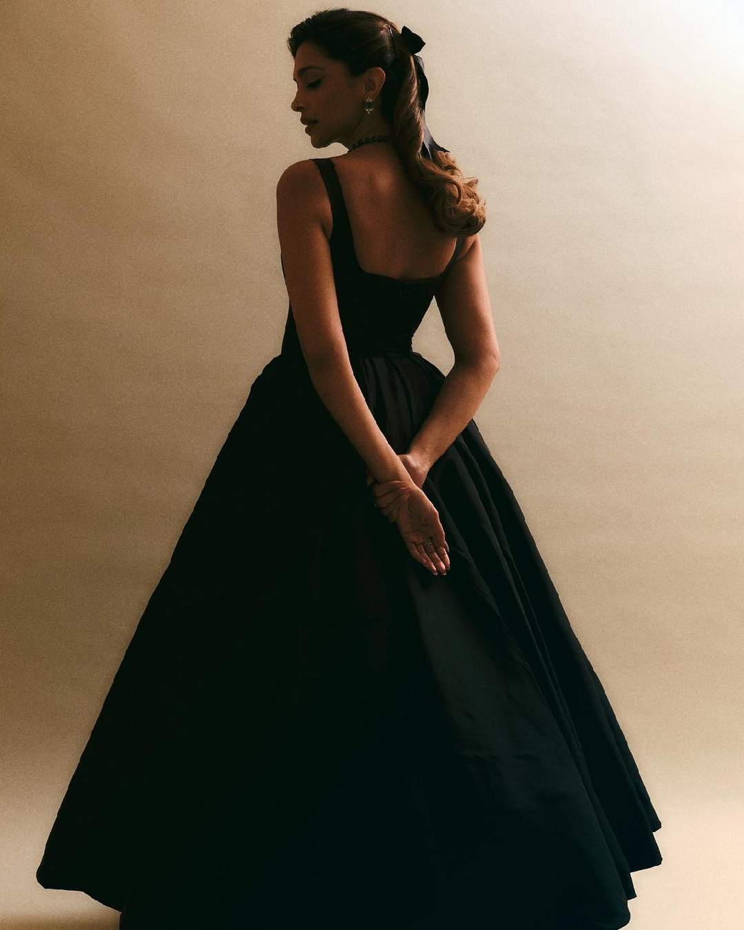 Deepika Padukone twirled in a black dress elevated by a matching black bow.