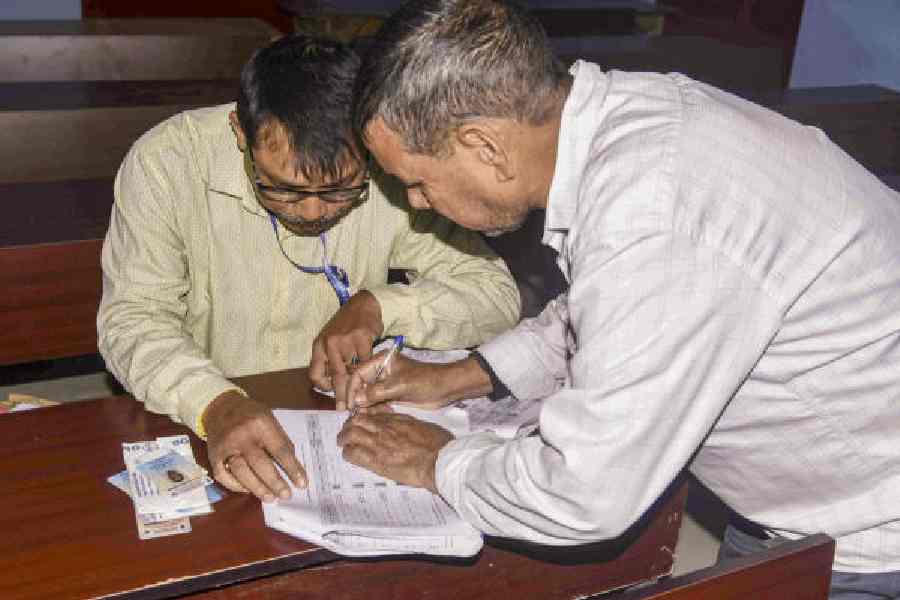 A booth-level officer assists a voter during verification as part of special revision of electoral rolls in Guwahati earlier this month.