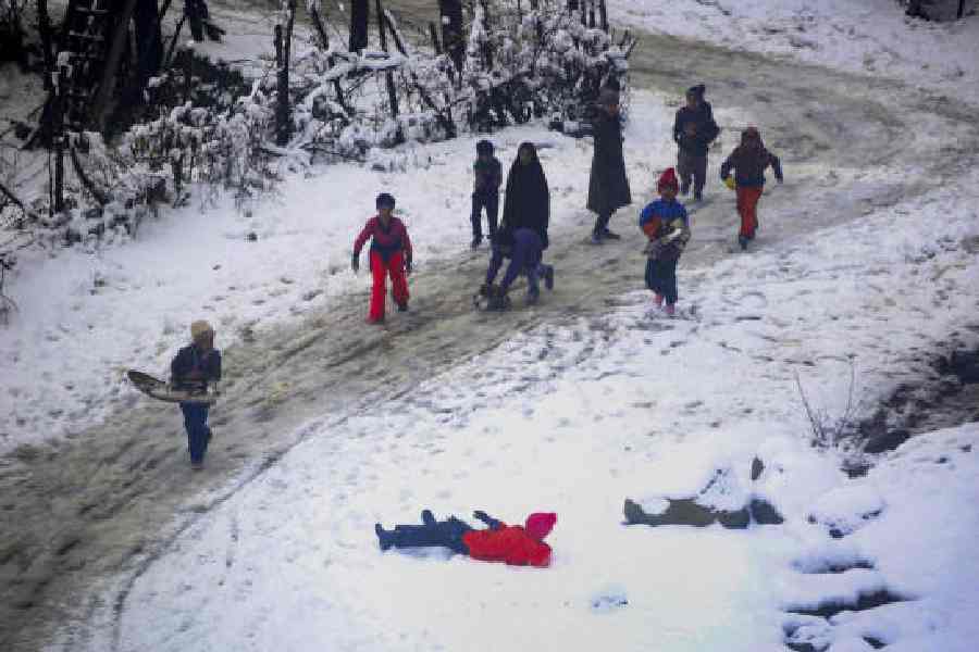 Children play with snow at Tangmarg in north Kashmir in January 2024.