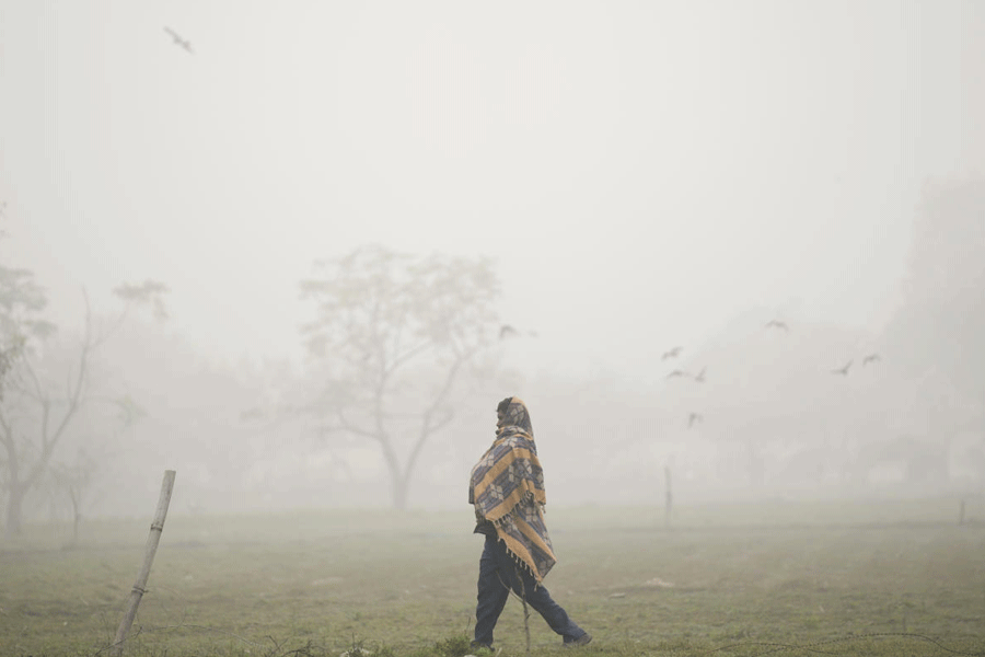 A man strolls amid low visibility on a foggy winter day, in New Delhi, Tuesday, Dec. 30, 2025.