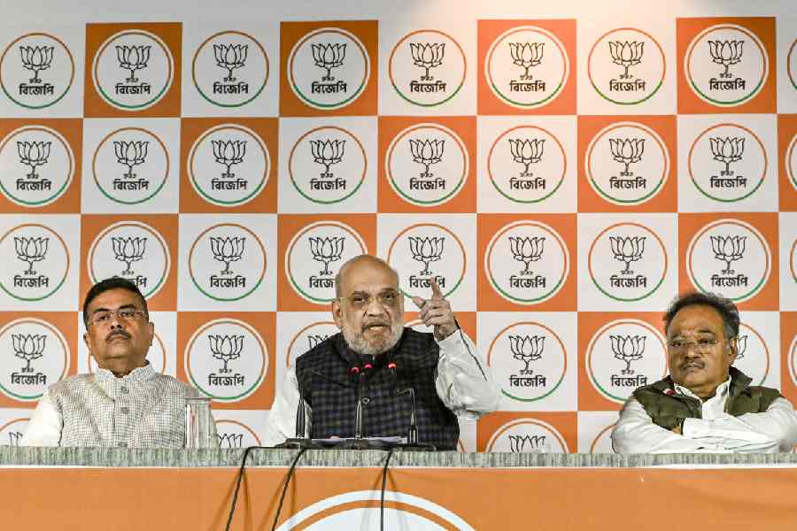 Flanked by BJP leaders Suvendu Adhikari and Samik Bhattacharya, Amit Shah addresses the press conference in Calcutta on Tuesday.