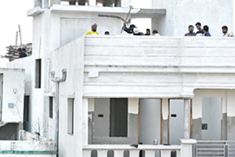 Workers demolish the six-storeyed tilted building on Christopher Road on Friday.