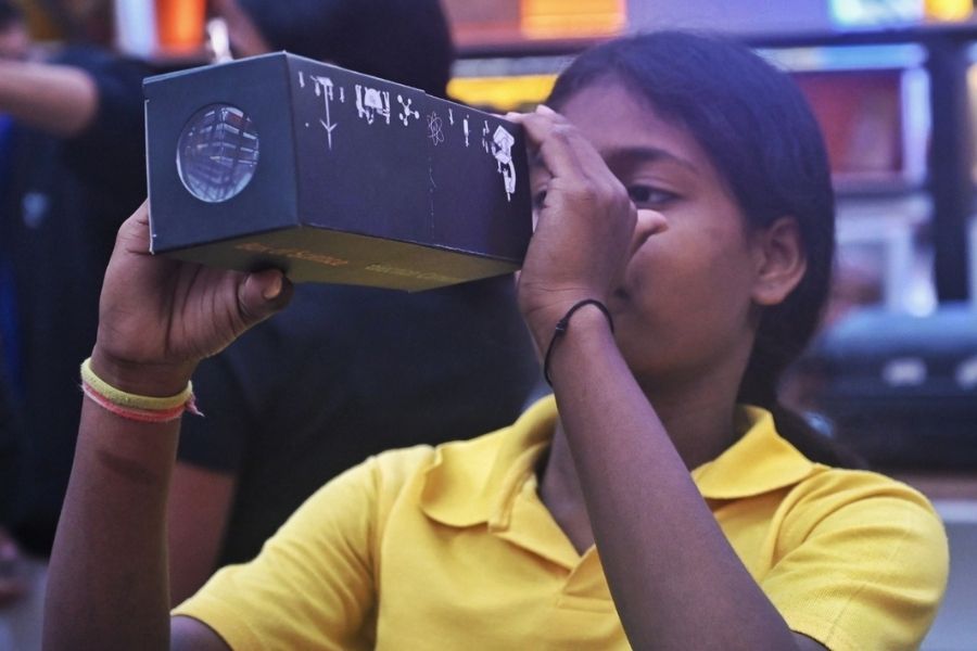 A student enjoys taking a look through a kaleidoscope at the pavilion