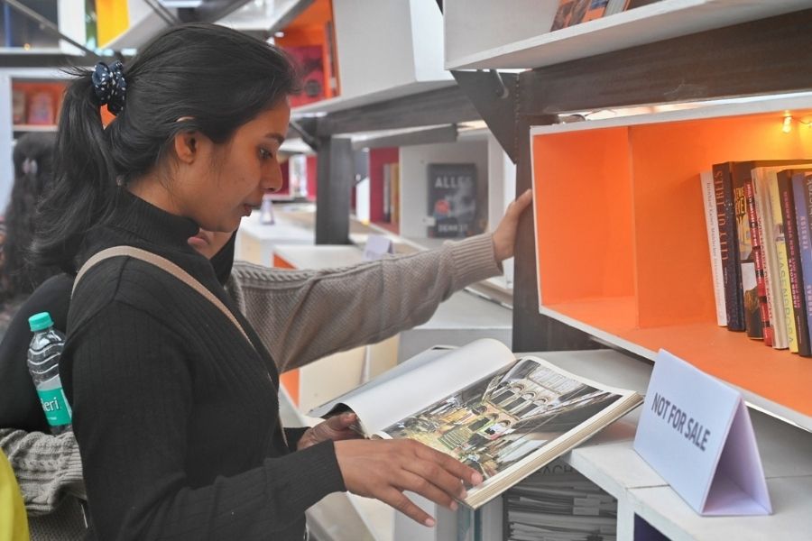 A reader engrossed in a graphic novel. The books at the stall are not for sale