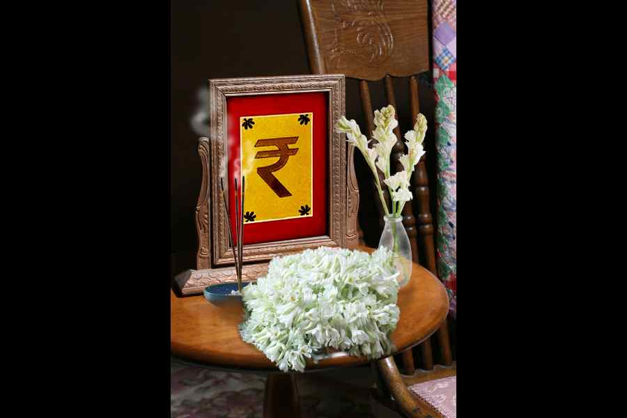 Vintage style photograph in antique frame sits on a table beside an old rocker with a postage stamp patterned quilt over the back of the rocker.