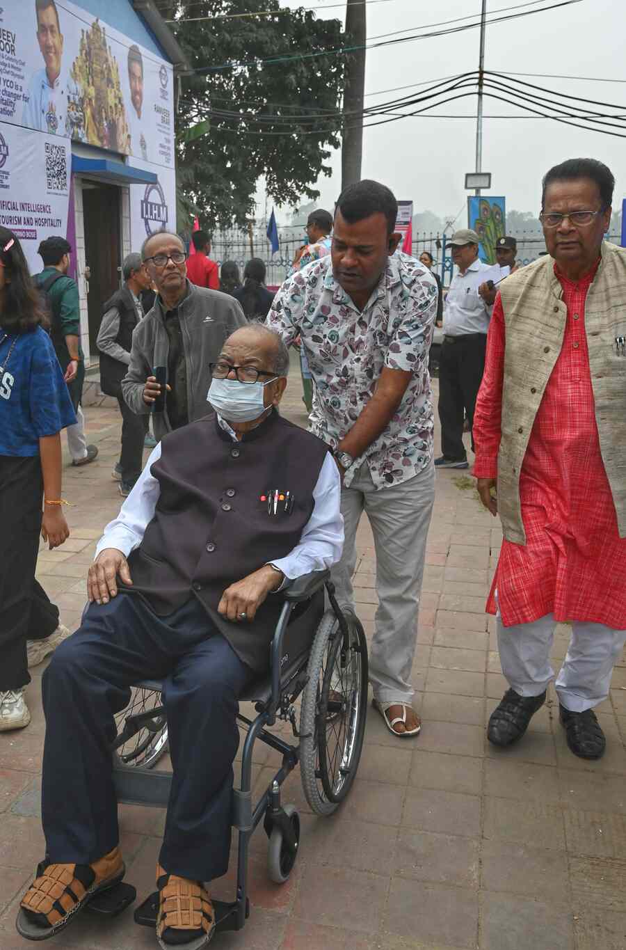 Author Mani Sankar Mukherjee arrives at the Book Fair in a wheelchair, masked to fight the dust and pollution