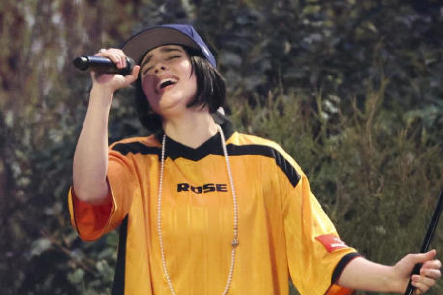 Billie Eilish sported an oversized yellow-and-black t-shirt teamed with a pearl-studded necklace and a blue baseball cap. 