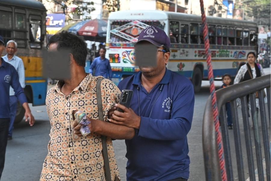 Civic volunteers minding traffic at the Exide crossing penalise a bus conductor of an errant bus on Wednesday