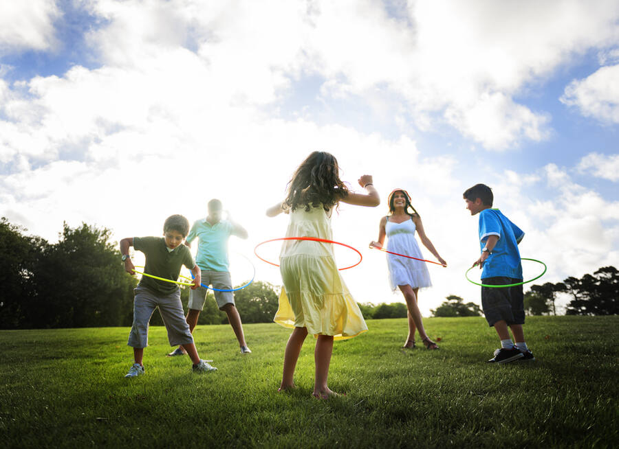 Family enjoying day in the park with hula hoops