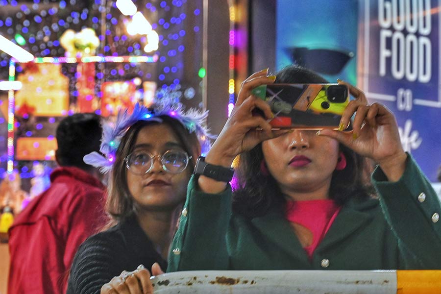 A youngster looks for that perfect angle to capture the festive lights on her phone
