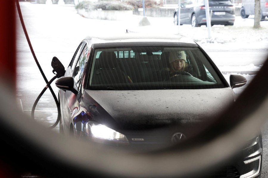 A woman charges her car at a station, in Sandvika near Oslo, Norway, December 11, 2024.  Reuters