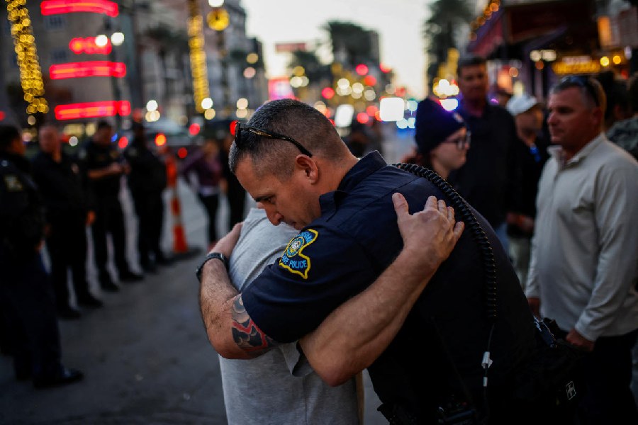 An on-duty officer embraces a mourner. 