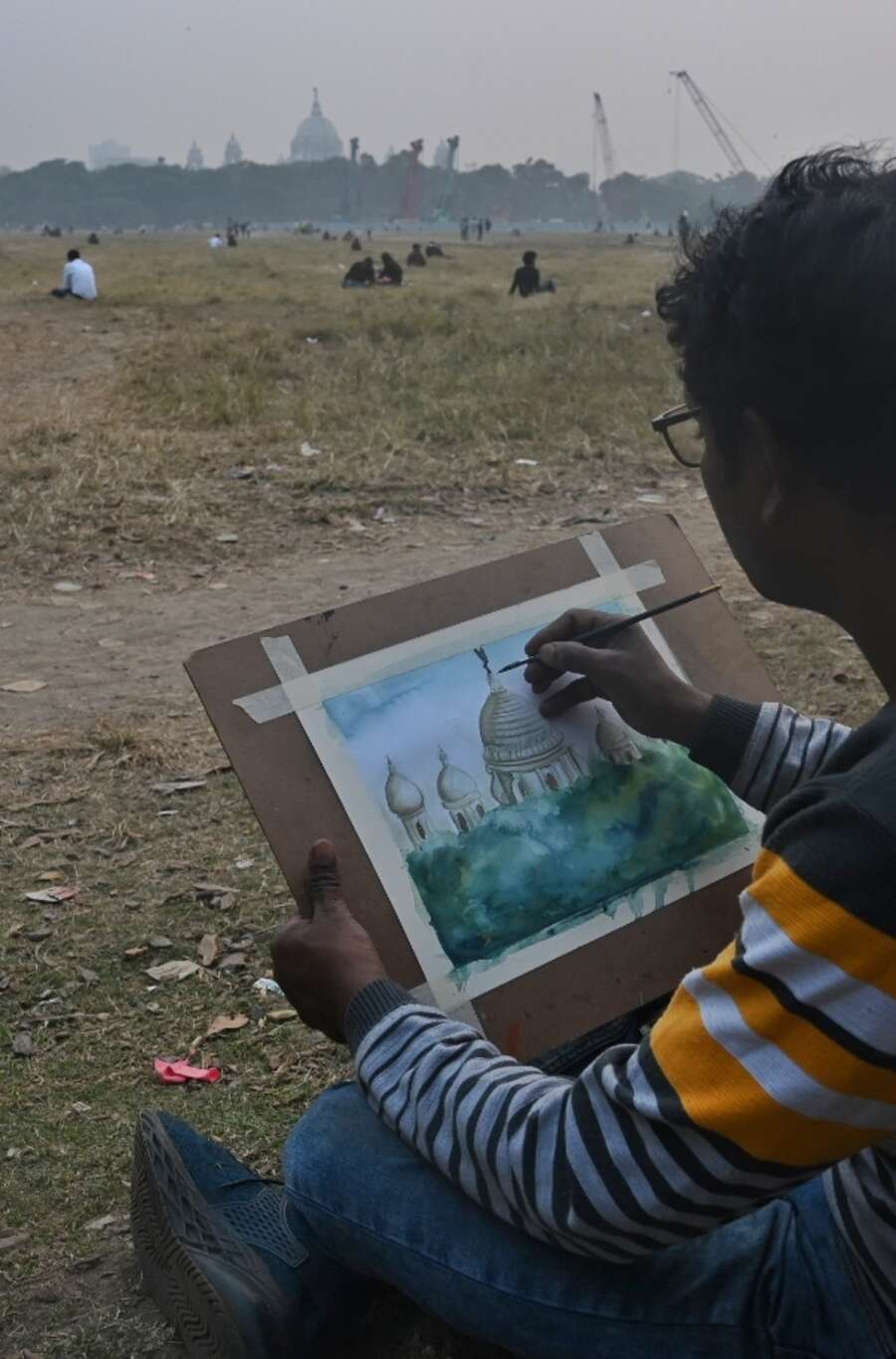 An artist paints the Victoria Memorial from Maidan on Tuesday