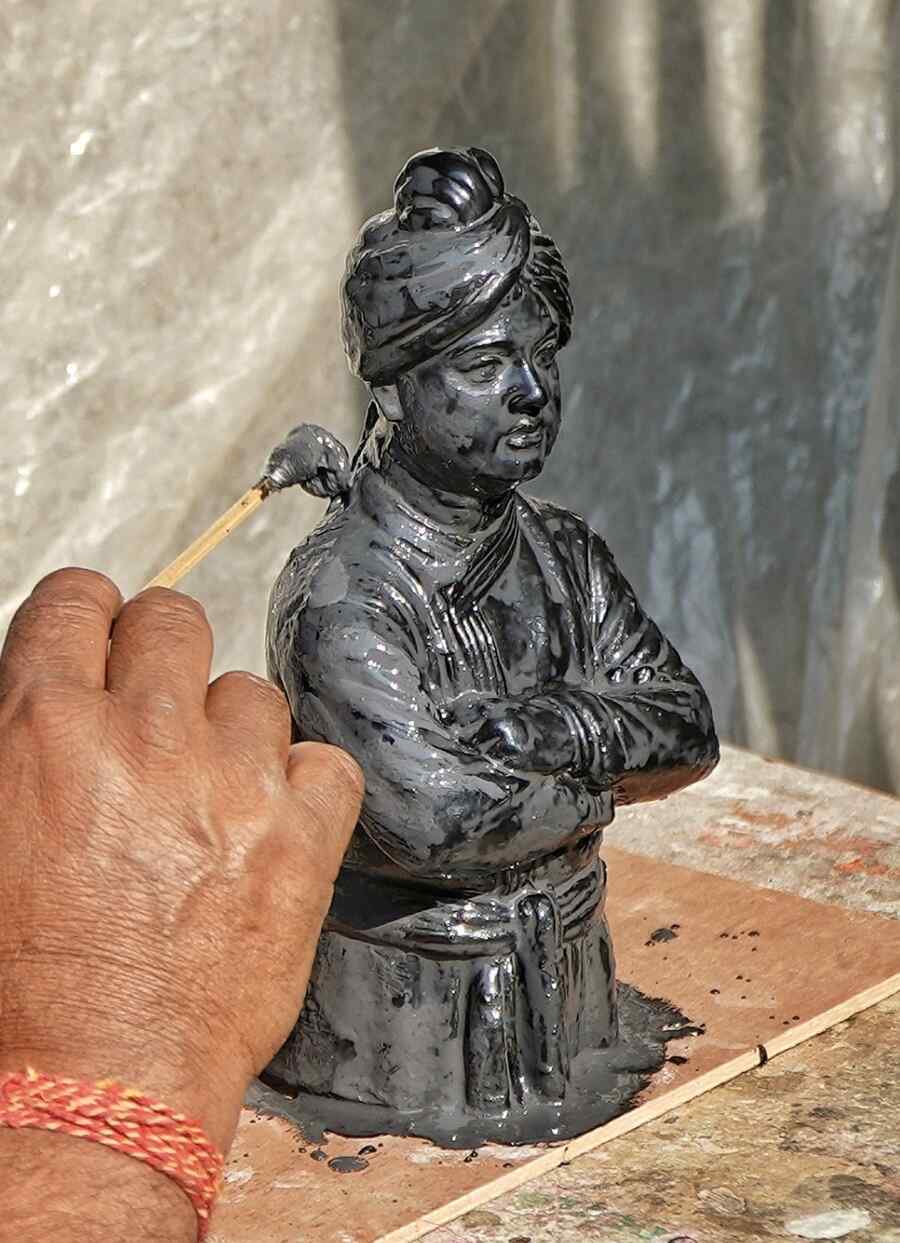 An artist lends finishing touches to a miniature model of Swami Vivekananda at Kumartuli on Wednesday ahead of his 162nd birth anniversary 