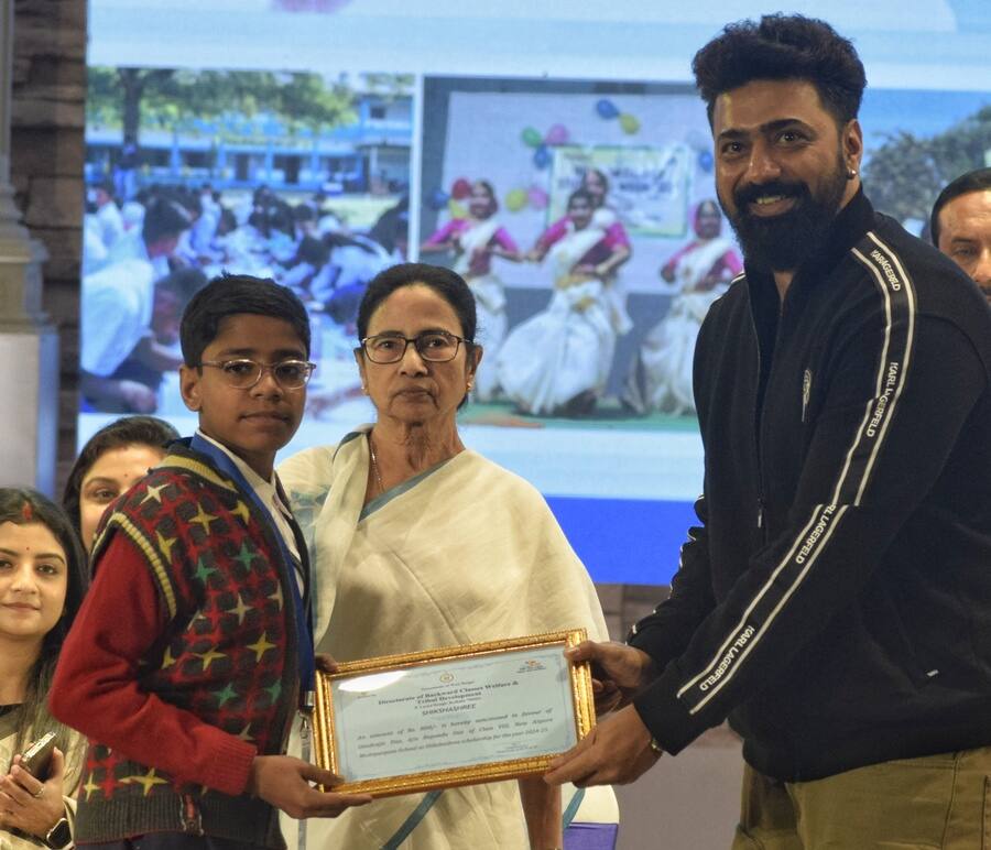 Actor-politician Dipak Adhikari hands over a certificate to a student in the presence of chief minister Mamata Banerjee on the last day of the Students’ Week at Dhono Dhanyo auditorium in Alipore on Wednesday