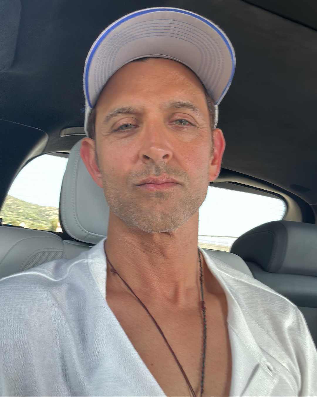 Hrithik has his selfie game on point. Sporting a breezy white shirt, a matching baseball cap, and a simple black string necklace, the actor nailed the casual look effortlessly. 