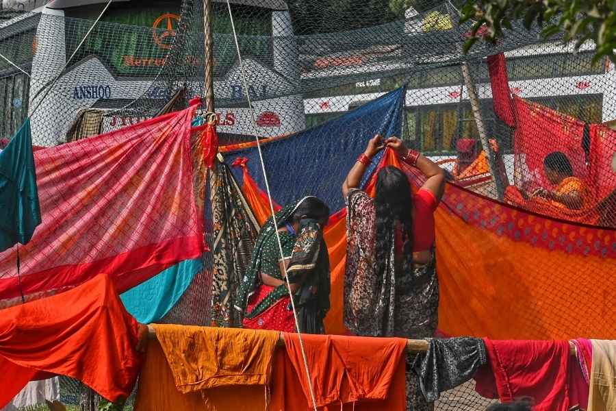 Gangasagar pilgrims use the cricket practice nets to dry clothes. Many pilgrims are staying at the transit camp in Babughat  