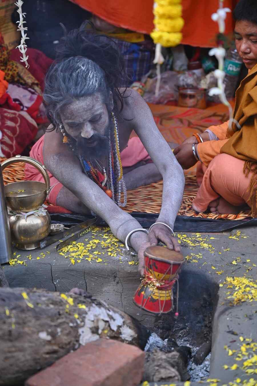 A sadhu heating his 'damru' at Babughat transit camp on January 6. Pilgrims from across India are travelling to Gangasagar Island for the Gangasagar Mela starting on January 14  