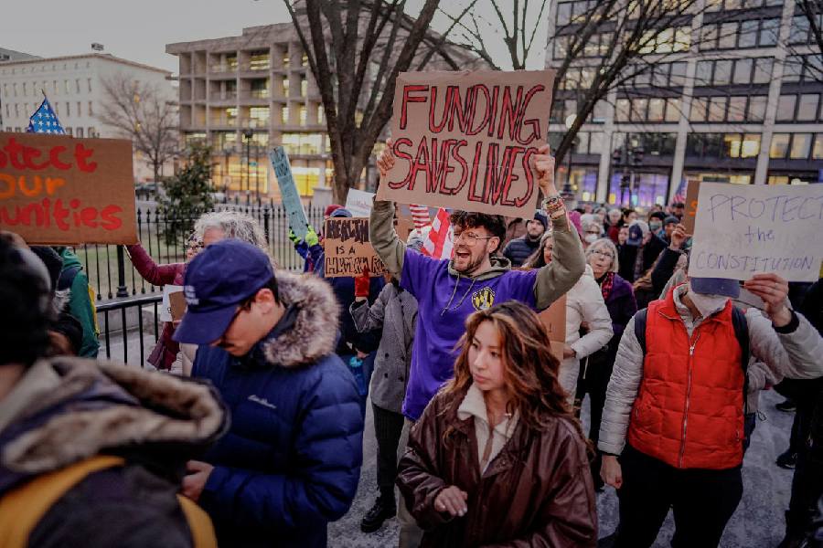 "Funding saves lives": reads one placard. A two-page internal memo that was circulated by the office of management and budget said that all federal loans and grants would be halted starting at 5pm on Monday. It said that financial assistance should be dedicated to “ending wokeness and the weaponization of government”.   “The use of Federal resources to advance Marxist equity, transgenderism, and green new deal social engineering policies is a waste of taxpayer dollars that does not improve the day-to-day lives of those we serve,” the memo added.