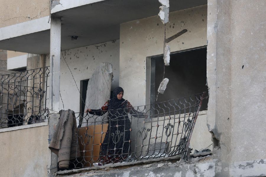 A Palestinian woman looks at the damage, at the site of an Israeli strike on a house that took place on Monday, in Zawayda in the central Gaza Strip, July 1, 2025.
