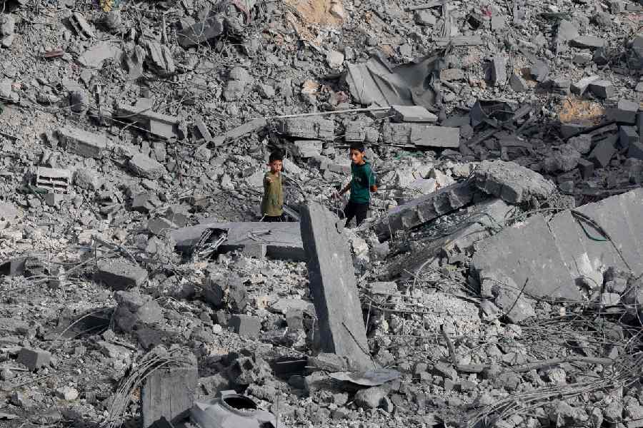 Palestinian boys stand at the site of an Israeli strike on a house that took place on Monday, in Zawayda in the central Gaza Strip, July 1, 2025.