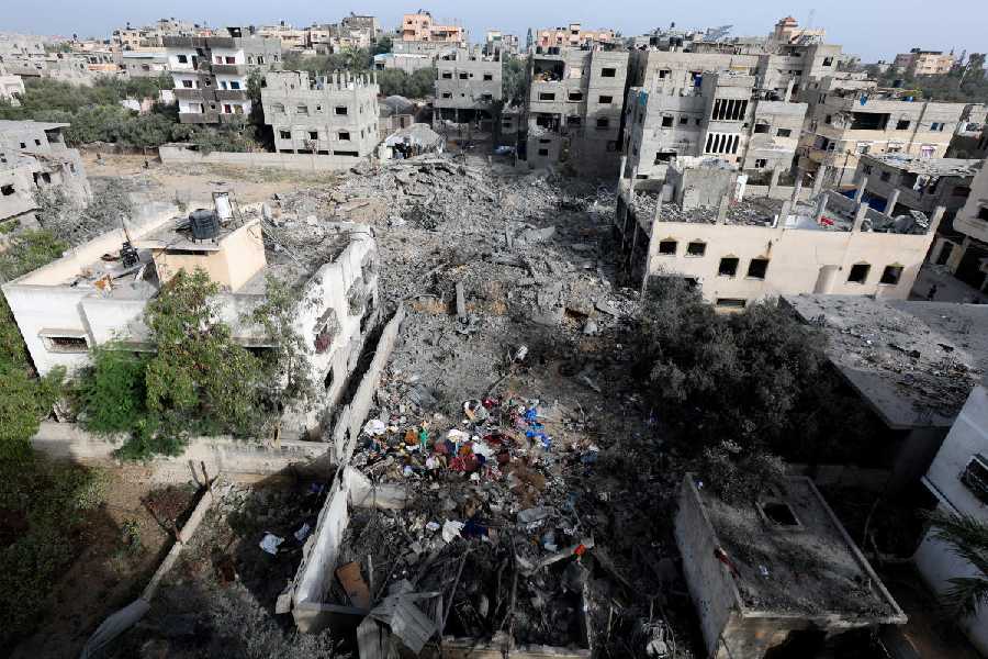 Palestinians inspect the site of an Israeli strike on a house that took place on Monday, in Zawayda in the central Gaza Strip, July 1, 2025.