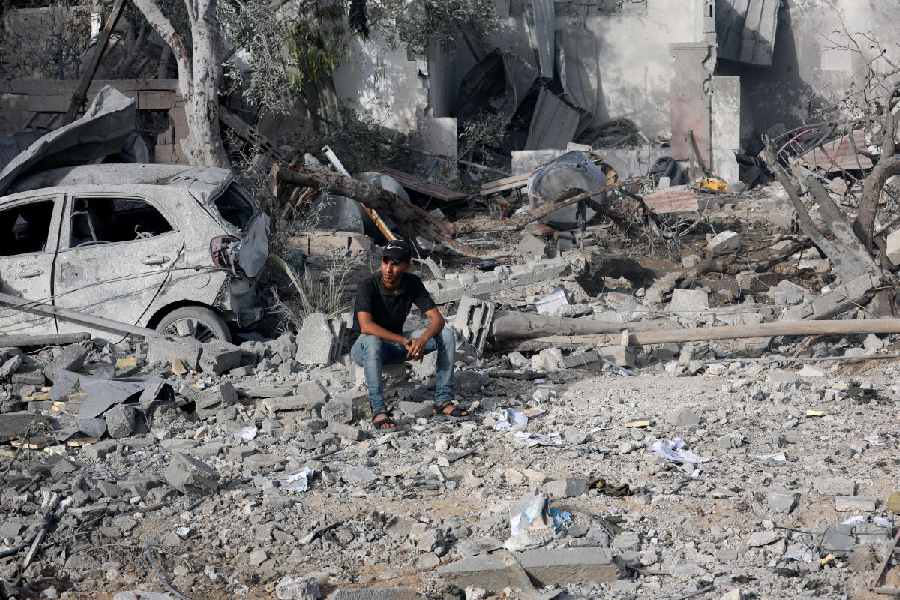 A Palestinian man sits at the site of an Israeli strike on a house that took place on Monday, in Zawayda in the central Gaza Strip, July 1, 2025.