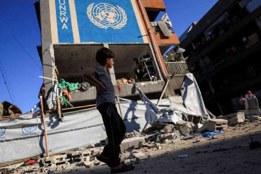 A Palestinian boy inGaza City walks past a UN school sheltering displaced people that washit during an Israelistrike on Saturday. (Reuters)