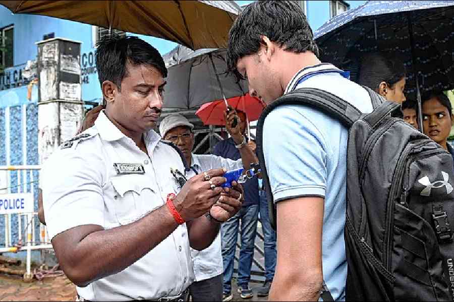 A policeman checks a student’s ID card on Monday morning