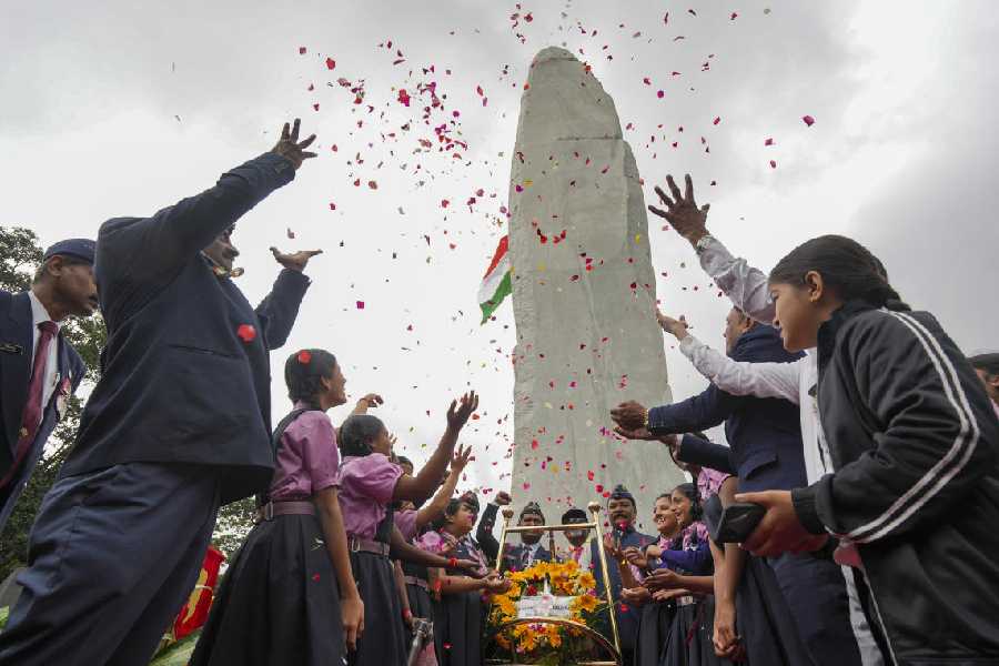 Students and veteran army staff during the unveiling of the 75-ft Veeragallu (hero stone) to mark the 26 years of Kargil Vijay Diwas, at National Military Memorial in Bengaluru