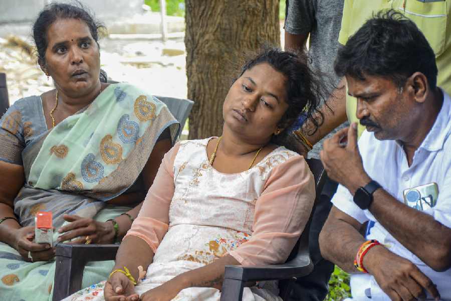 Bereaved mother, center, of Divyanshi, a victim of the stampede near the Chinnaswamy Cricket Stadium, mourns at her residence, in Bengaluru