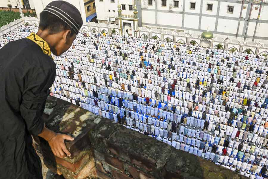 A child watches as people offer ‘namaz’ on the occasion of ‘Eid-ul-Azha’ festival, in Howrah district, West Bengal.
