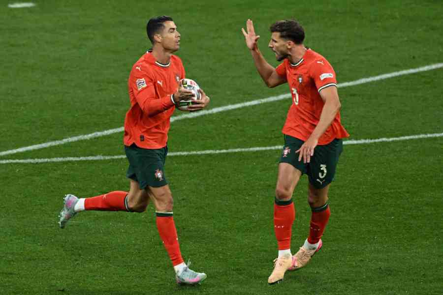 Portugal's Cristiano Ronaldo celebrates scoring their second goal with Ruben Dias