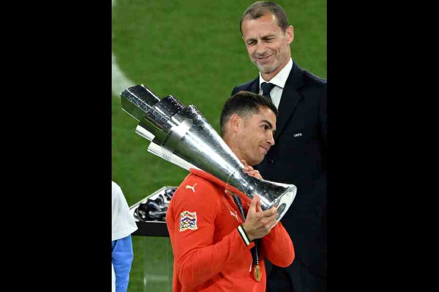 Portugal's Cristiano Ronaldo collects the trophy from UEFA president Aleksander Ceferin after winning the Nations League