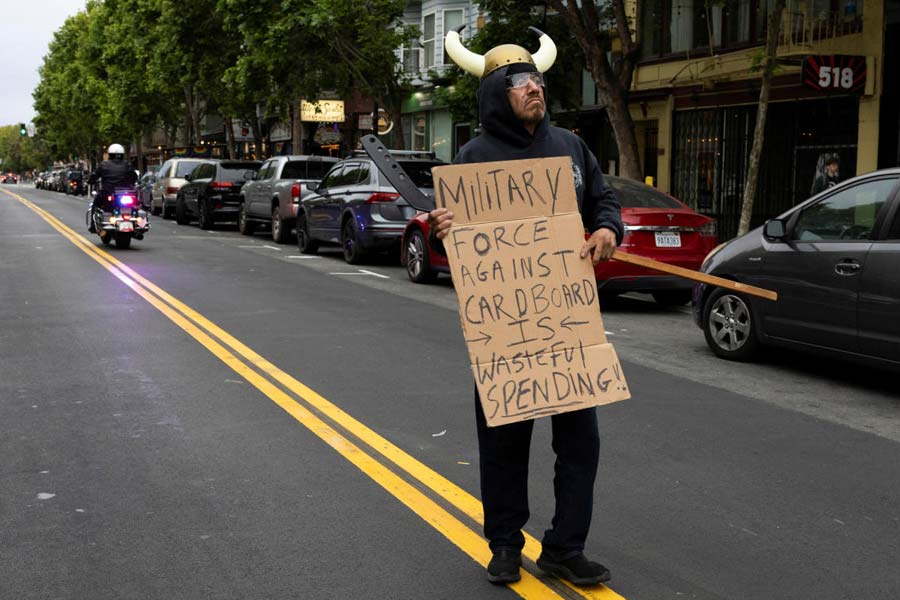 A demonstrator holds a placard as people protest in the Mission District against federal immigration sweeps, in San Francisco, California, U.S. Trump has described Los Angeles in dire terms that Mayor Karen Bass and Newsom say are nowhere close to the truth. They say he is putting public safety at risk by adding military personnel even though police say they don't need the help.