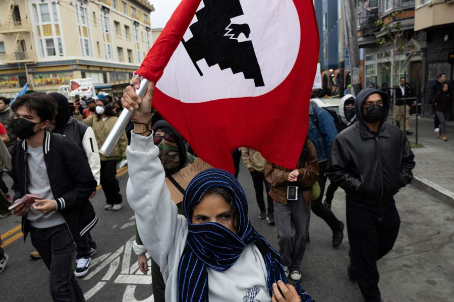 A demonstrator waves a United Farm Workers flag during a protest in the Mission District against federal immigration sweeps, in San Francisco, California, U.S.