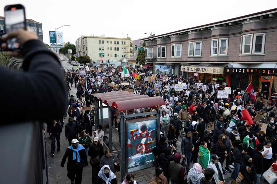 Demonstrators march in the Mission District during a protest against federal immigration sweeps, in San Francisco, California, U.S.