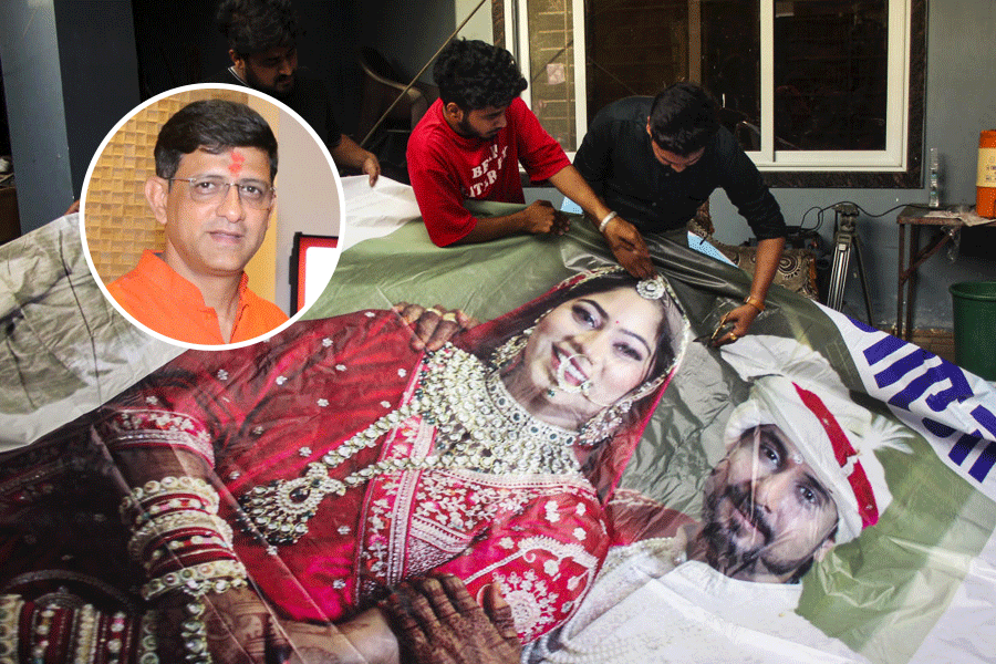 Family members of Raja Raghuvanshi, who was allegedly murdered during his honeymoon in Meghalaya, cut out the picture of his wife Sonam Raghuvanshi from a poster of their marriage after she was accused of plotting his murder, in Indore, Tuesday, June 10, 2025.