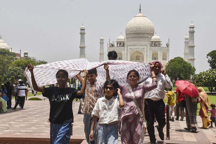Agra: Tourists try to shield theselves from the scorching heat and strong sunlight while visiting the Taj Mahal, in Agra