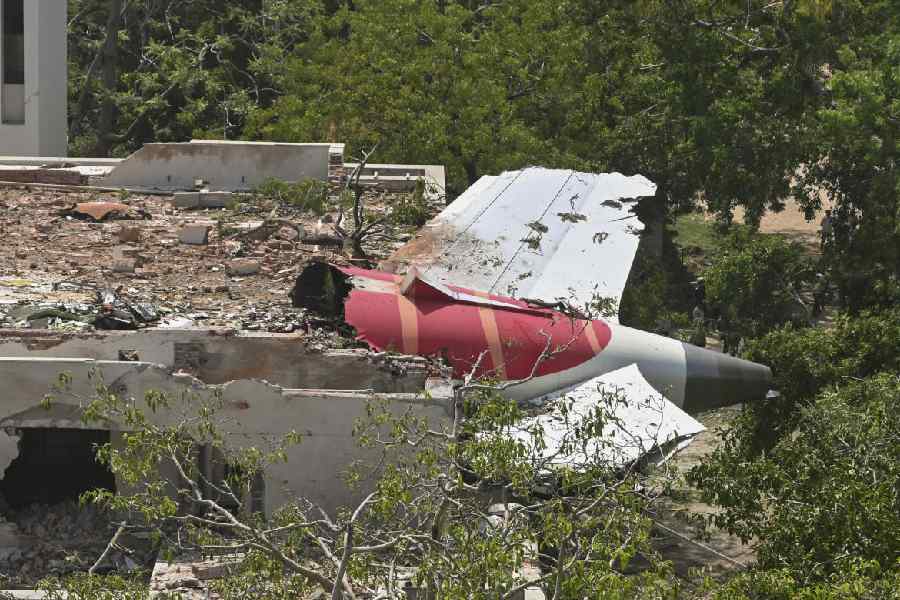 A portion of the crashed plane juts out of a residential building in Ahmedabad on Thursday.