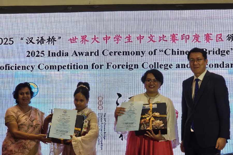 Chinese consul general Xu Wei (right) and principal of St. Joan's School Debjani Ghosh hand over prizes to the winners.