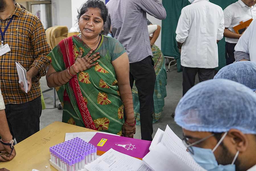 Relative of a victim of the Air India plane crash reacts as she gives her DNA sample for identification of bodies at a hospital