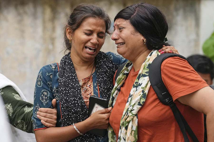  Relatives of a victim of the Air India plane crash mourn outside a hospital in Ahmedabad