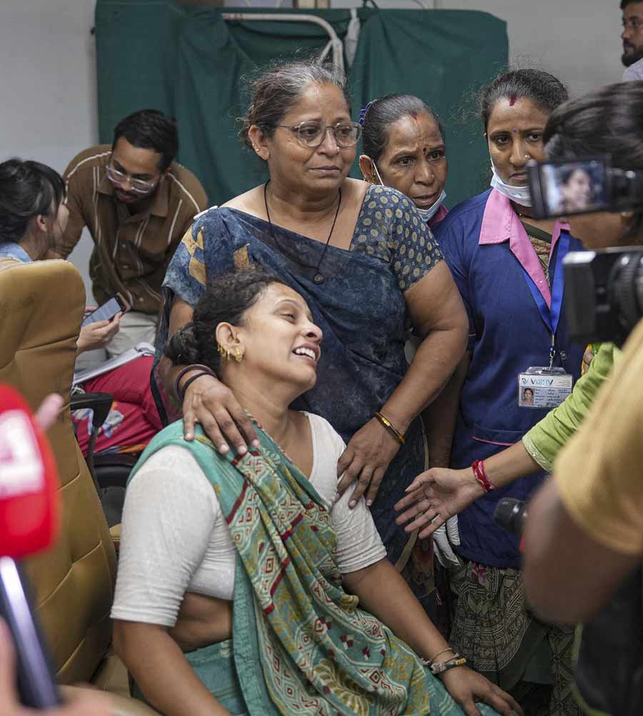 Kin of a victim of the Air India plane crash mourn and console each other.