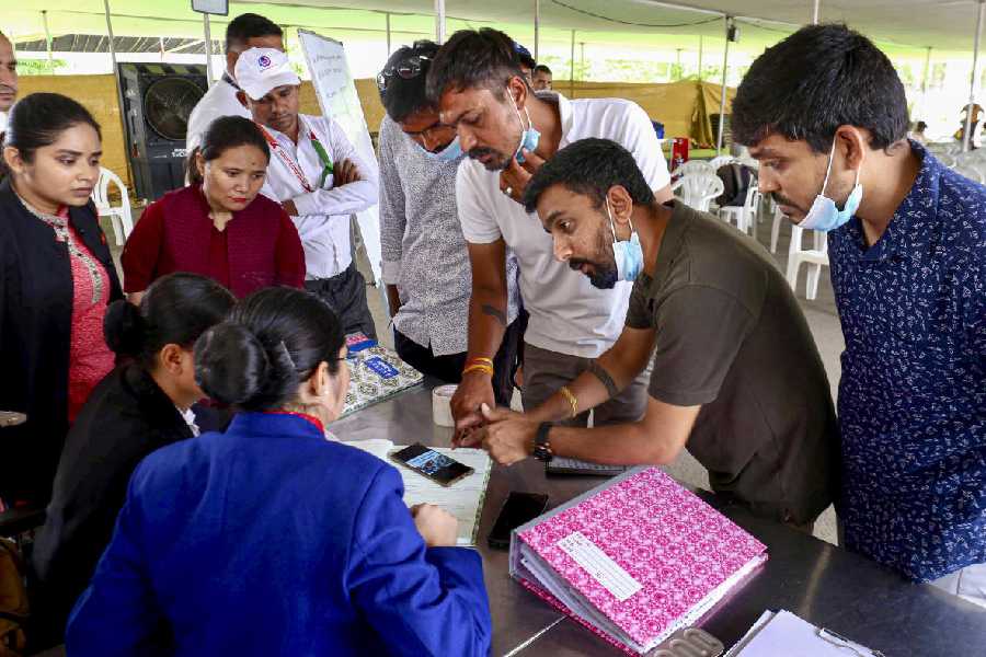 People submit documents at a help desk set up after the tragedy to claim luggage and other belongings of their deceased relatives who died in the Air India plane crash, at Sardar Vallabhbhai Patel International Airport, in Ahmedabad.