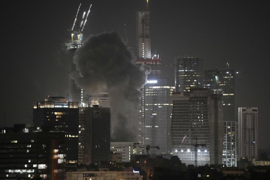 Smoke billows after a projectile hit a building in Tel Aviv, Israel