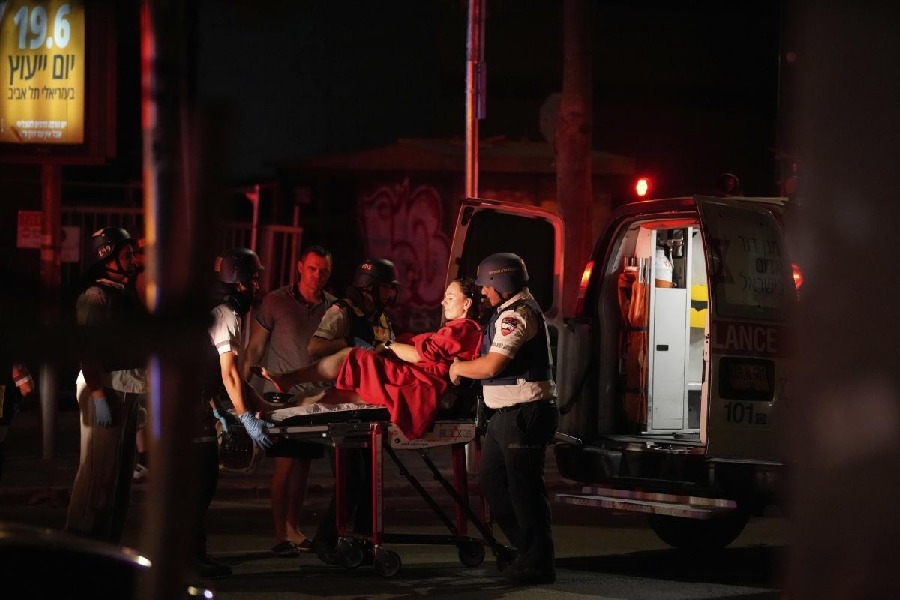 Paramedics evacuate a wounded woman from a building struck by a missile