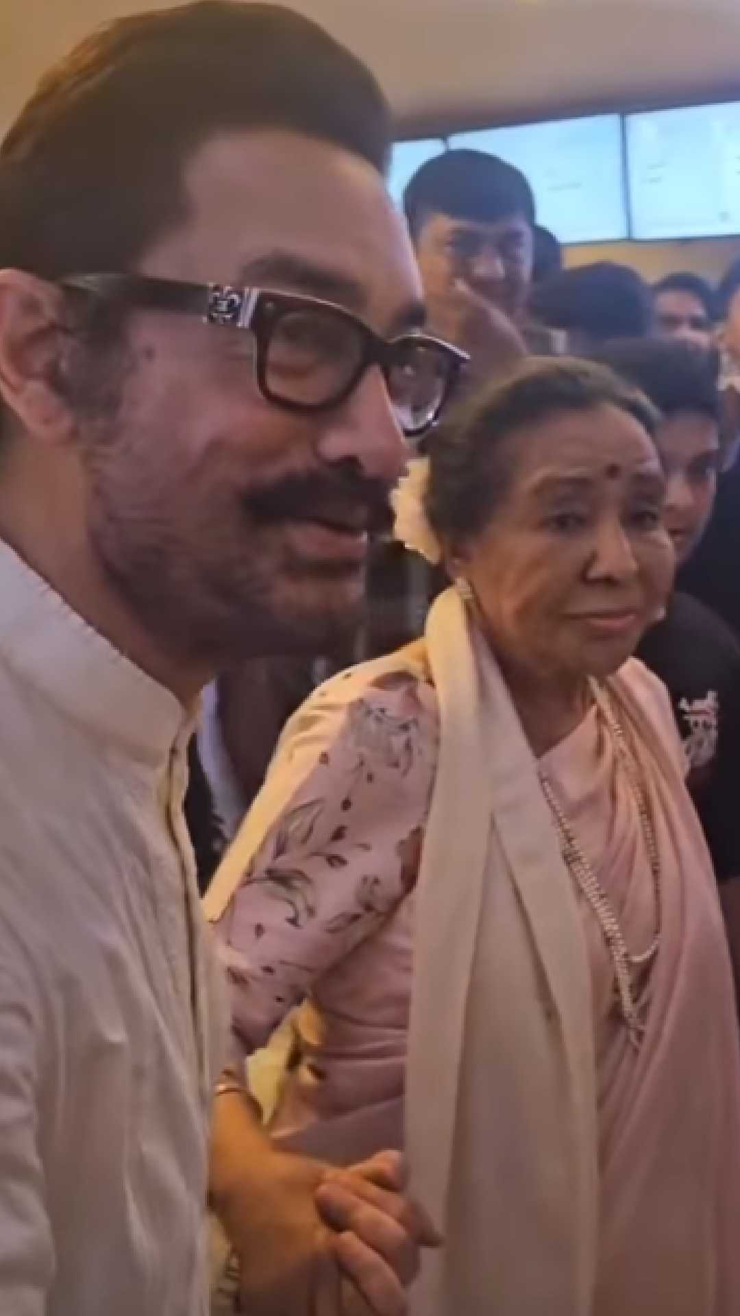 Veteran singer Asha Bhosle held Aamir Khan’s hand as she walked into the premiere venue. She looked gorgeous in an ivory sari.  
