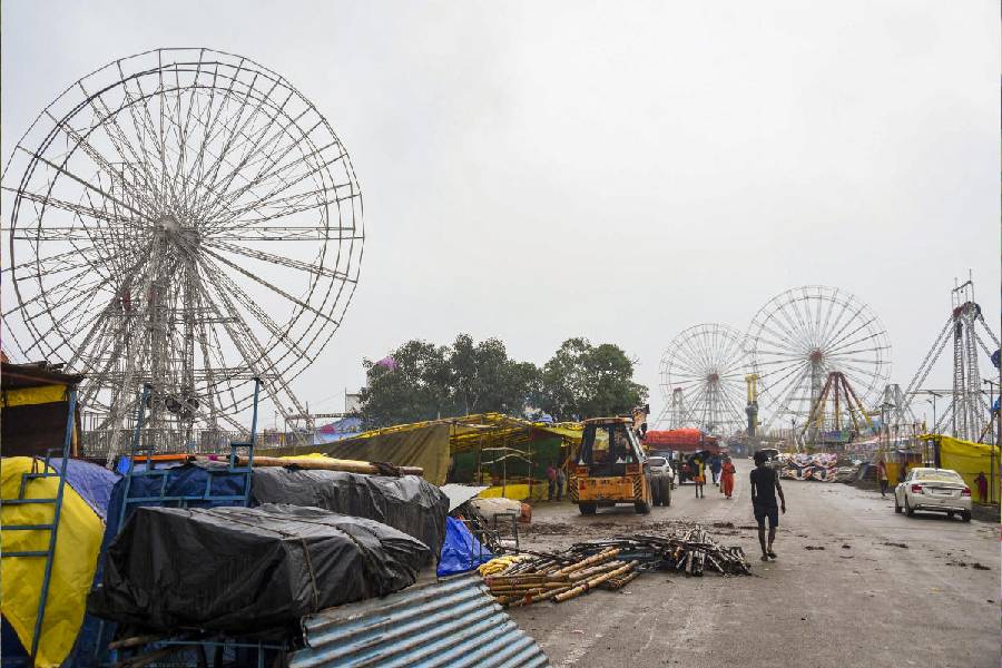 People walk past ferris wheels amid preparations for the upcoming annual ‘Rath Yatra’ festival, in Ranchi